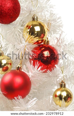 Red and golden decorations are on white Christmas tree.