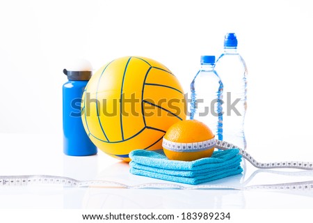 Diet diabetes weight loss concept with ball, tape measure, organic orange, towels and sprt bottle with bottles of natural sparkling water on a white background.