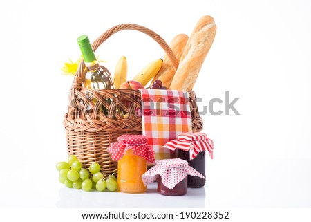 Composition of picnic basket, baguettes, grapes, bottle of wine, jam jars