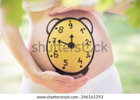 Conceptual image of pregnant belly with painted clock