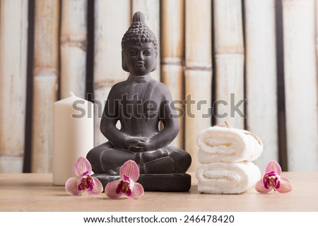 Buddha, white candle and towels, orchid flowers
