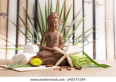 Buddha statue with towels and starfish - wellness concept