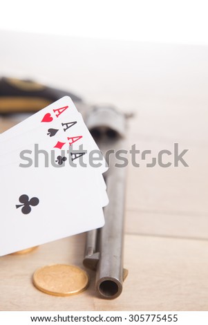 Four aces vintage poker game playing cards on a weathered wood table in an old western frontier gambling establishment saloon