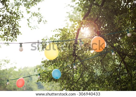 Hanging decorative baloons and lights for a back yard party
