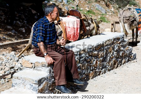Crete,Greece - OCTOBER 11: The old man carries on donkeys in the Lassithi plateau on October 11,2014,Greece