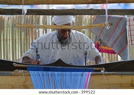 oman man operating machine making clothes