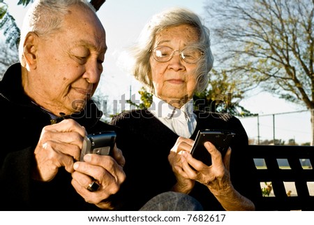 Grandpa looking at Grandmas palmtop computer screen