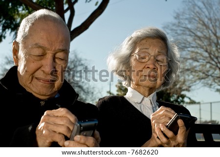 Grandma sneaking a peak into grandpa\'s handheld computer