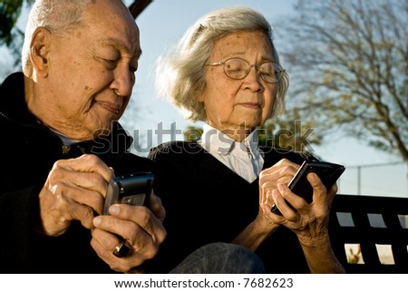Grandpa looking at Grandmas palmtop computer screen again and again