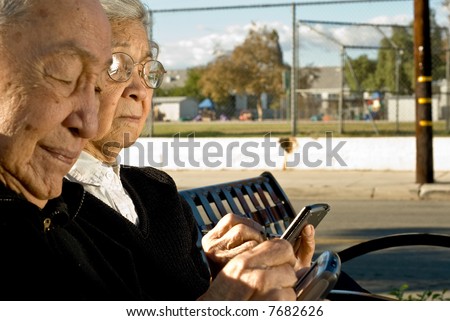 Side image of grandma and grandpa to the left of the frame as they hold their palmtop computers and enter information.