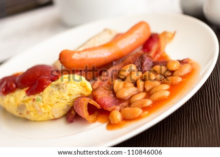 American breakfast with sausage, omelet, baked beans