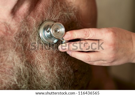 Stethoscope  on the hairy male chest - The doctor listens to the heart
