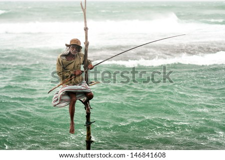 Galle, Sri Lanka - Circa November 2009: The Old Man Goes Fishing In The Traditional Way While Sitting On A Pole Circa November 2009 In The Town Of Galle.