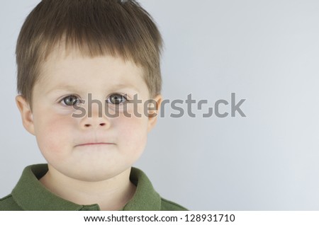 Determined little boy, with lips pursed like he is ready to do whatever,set off to the left of the frame.