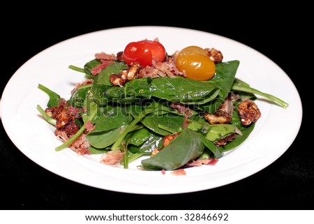 Spinach salad with some bright red cherry tomatos
