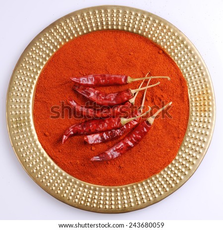 red dry chillies and chilly powder on antique plate