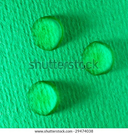 Three green water drops on paper
