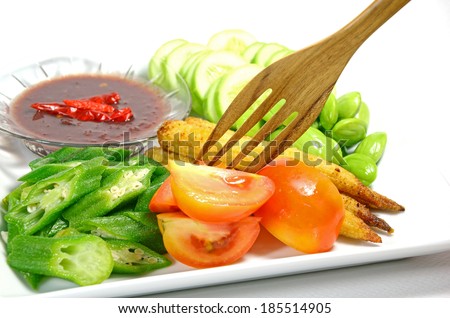 Mixed vegetable menu with sliced cucumber, tomatoes, grilled baby corn, boiled okra and fresh stink beans mostly served with Shrimp-paste sauce in Thai food menu.
