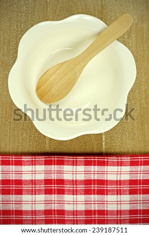 Red Table Cloth and Flower Shape Bowl Soup with Old Wooden Table Background.