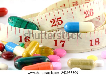 Medicine and Tape Measure on White Background in Waistline and Weight Control Concept.