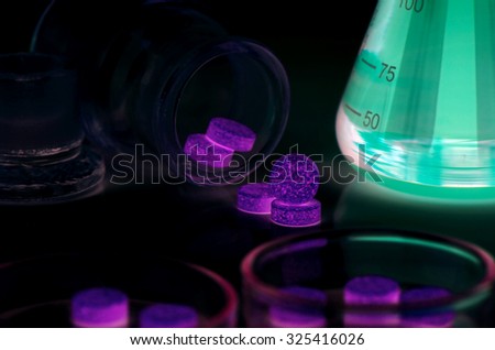 Medicine and Laboratory Glassware on UV Light.