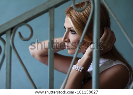 Young woman in profile against a blue wall in vintage style