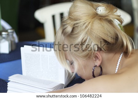Beautiful blonde fell asleep over a book