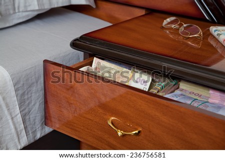 Bundles of banknotes in bedside table filled with Ukrainian cash