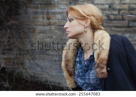Close-up portrait in profile of beautiful girl in vintage style on stone wall background