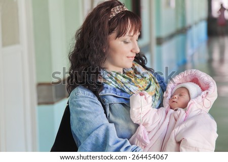 Young mother with newborn baby in hospital at the day of discharge from maternity ward