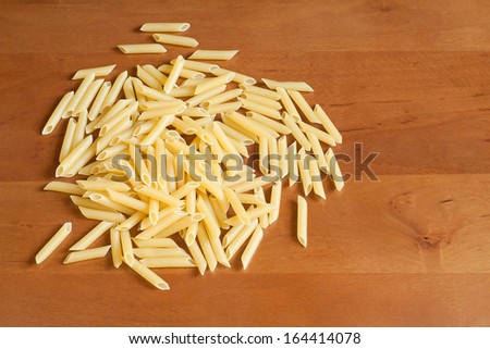 Raw pasta, macaroni,  on a wooden table