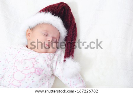 newborn baby girl sleeping, with santa Christmas hat