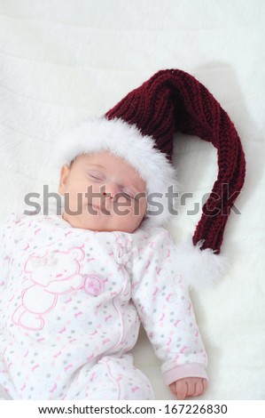 newborn baby girl sleeping, with santa Christmas hat