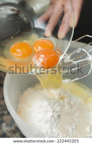 Mixing egg, flour and sugar cream in bowl with motor mixer. Kneaded dough for baking a cake