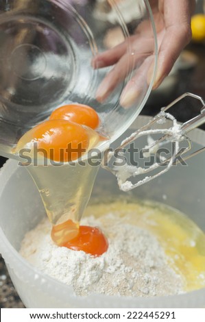 Mixing egg, flour and sugar cream in bowl with motor mixer. Kneaded dough for baking a cake