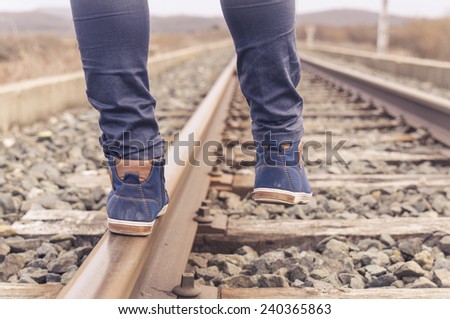 Feet on urban shoes on a train railway