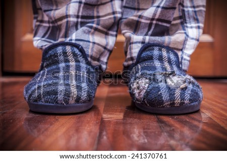 Man feet at home with broken slippers. Poverty