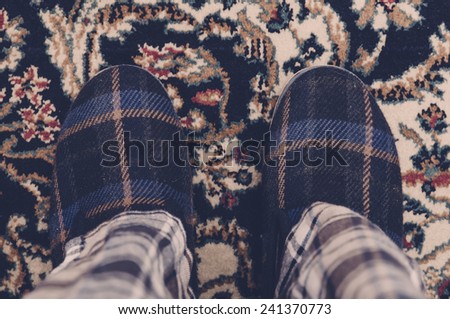Man feet at home in pajamas and winter slippers