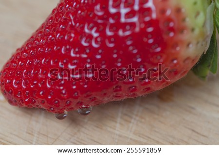 Strawberry on wooden table, with water drops