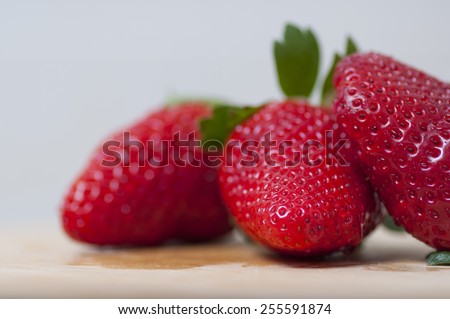 Strawberries on wooden table, with water drops