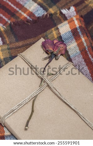 Present wrapped, decorated with a flower, on a wool blanket