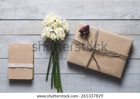 White narcissus flowers, notebook and present on wooden background