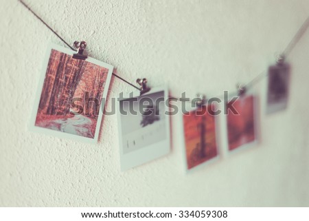 Some photos hanging on a rope, white wall background