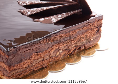 Chocolate glossy dark Cake on white stuffed with nuts