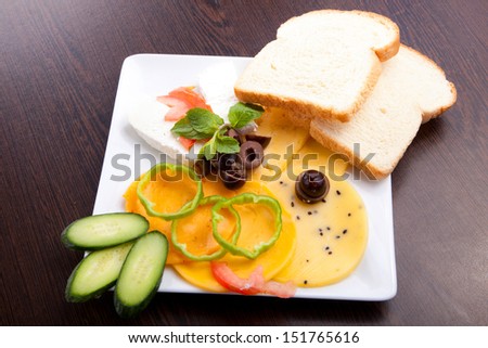 Cheese and olive, tomato platter with vegetable and herbs