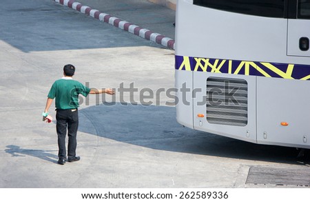CHIANG MAI, THAILAND - FEBRUARY 28 2015: Man give signs for bus Reverse out of terminal. Bus of Greenbus Company. Photo at New Chiangmai bus station, thailand.