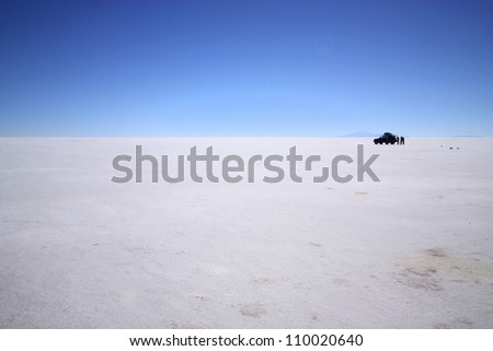 Spectacular white salt landscape with car  in the middle of salt desert, Uyuni, in Bolivia near border with Chile, south America.