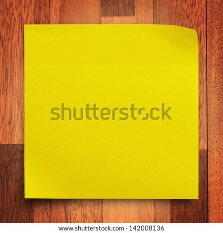 Yellow sticker paper note on wood wall background