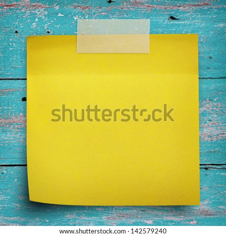 Yellow sticker paper note with scotch strip on vintage wall