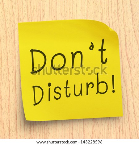 Do not disturb note on yellow sticker note on plywood wall
